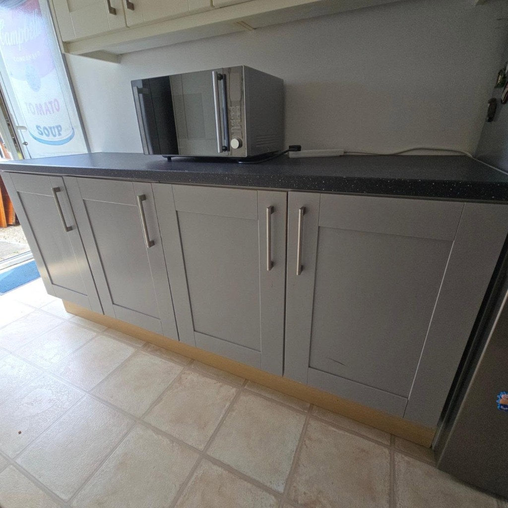 The utility room before the oak worktop, with a dark worktop and grey unit doors