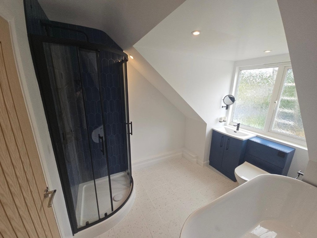 Finished bathroom with the quadrant shower, basin and freestanding bath