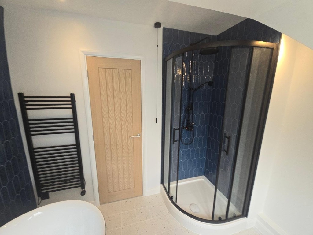 Black quadrant shower, oak door and towel rail