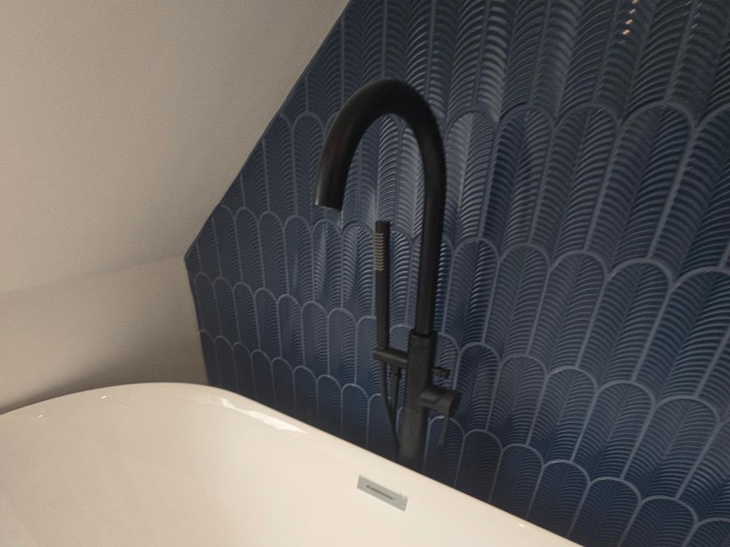 Black freestanding bath tap and blue scallop feature tiles