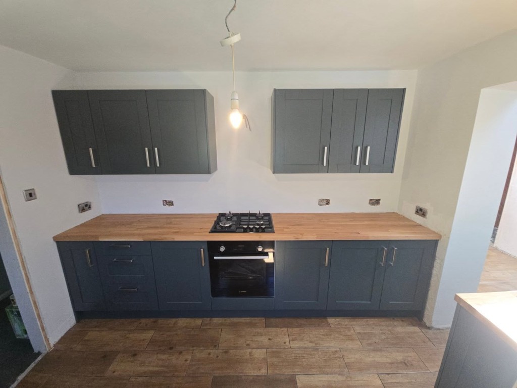 Wall and base units with an oak worktop and gas hob