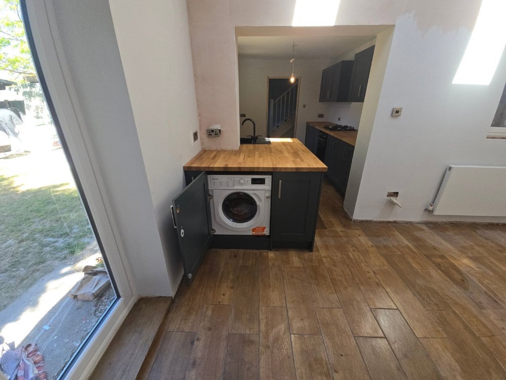 Integrated washing machine under the oak worktop by the window