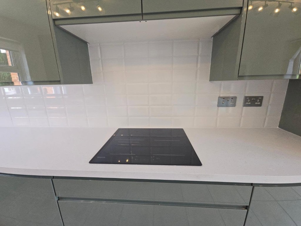 Induction hob set into the white worktop against a subway tile splashback