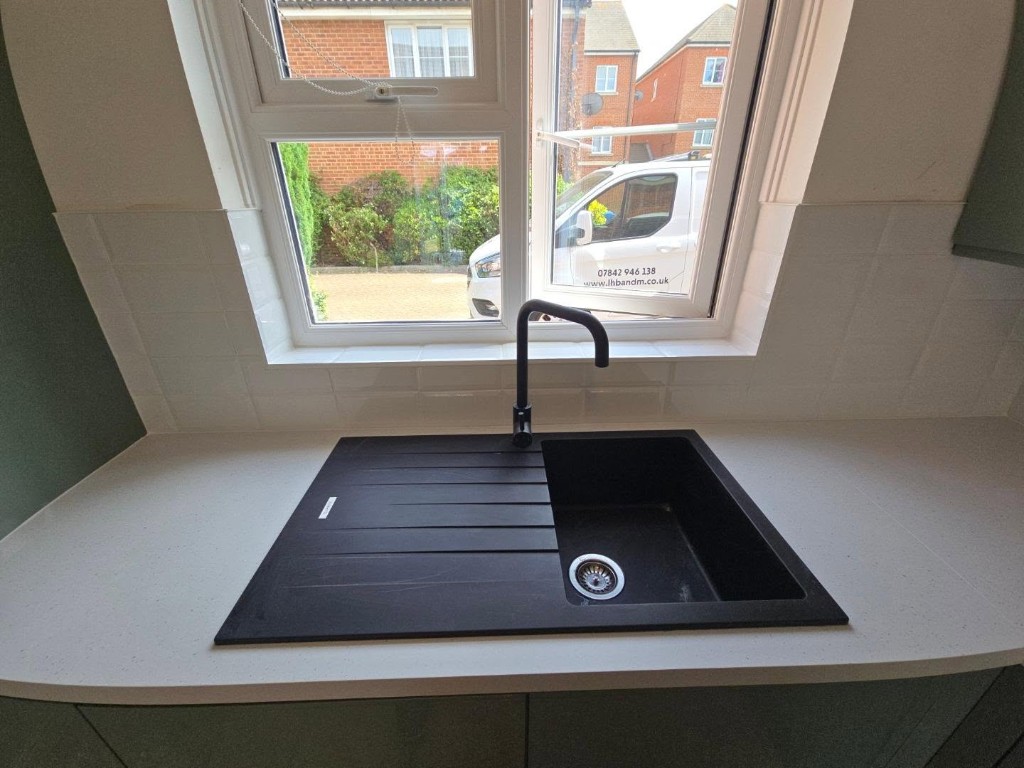 Black sink and tap with the white subway tile splashback