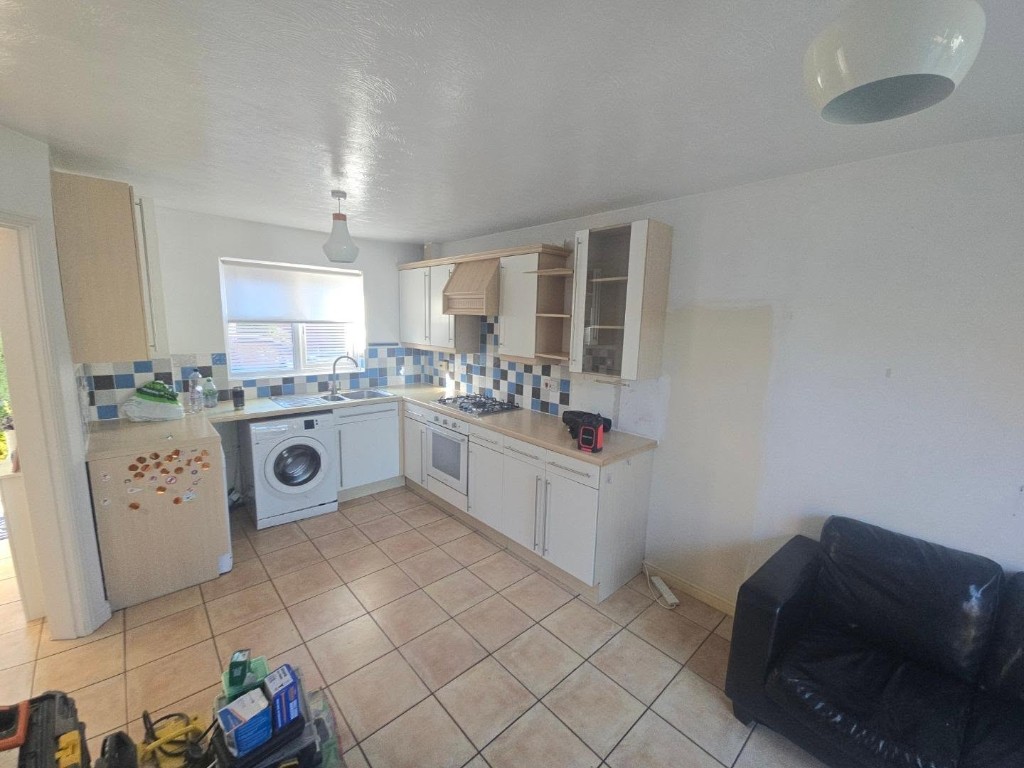 The original kitchen, with blue wall tiles and the old units still in place